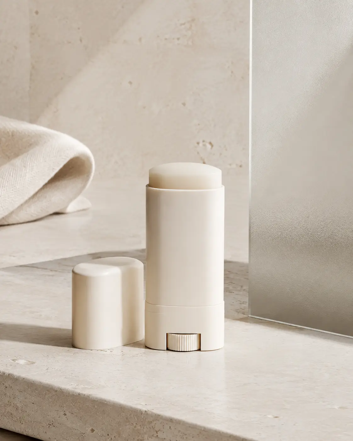 Composição editorial minimalista com stick de skincare em pedra clara
